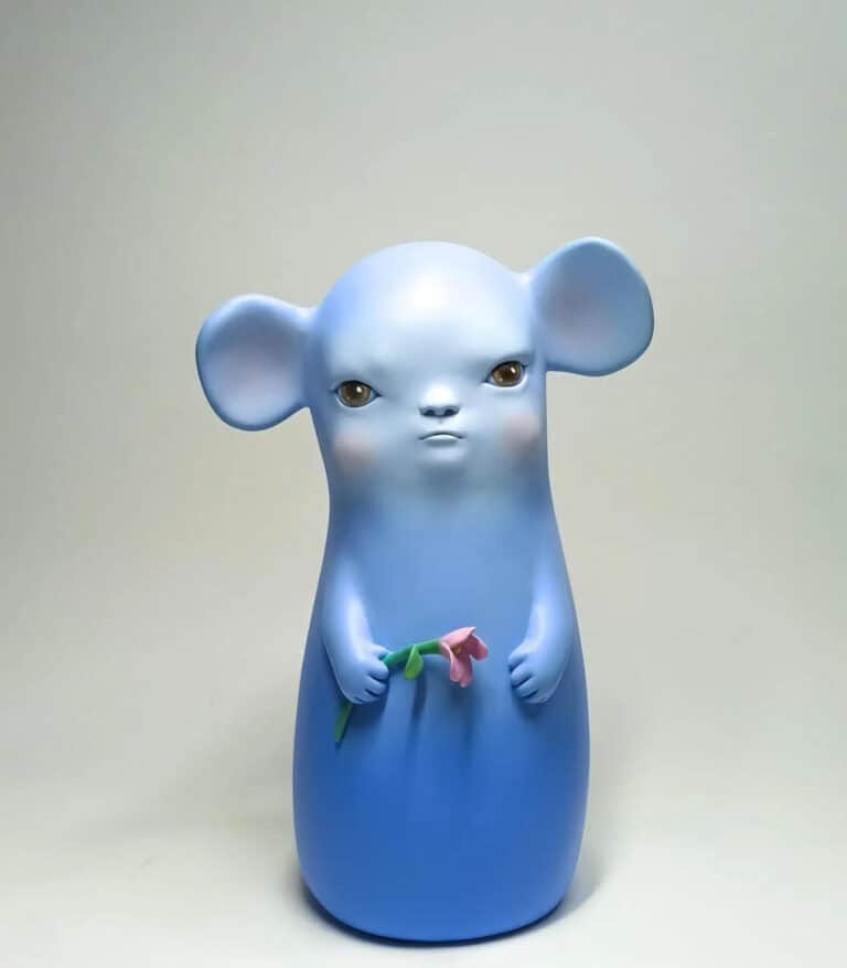 a blue figurine of a mouse holding a flower